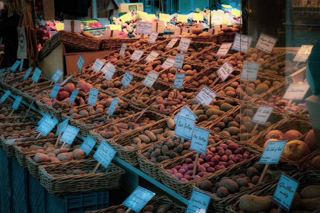 A small shop with lots of different types of potatoes