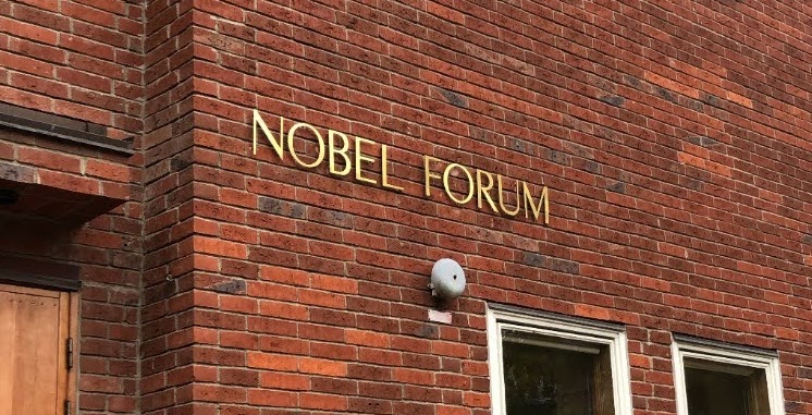 Golden letters saying "NOBEL FORUM" on a red brick building