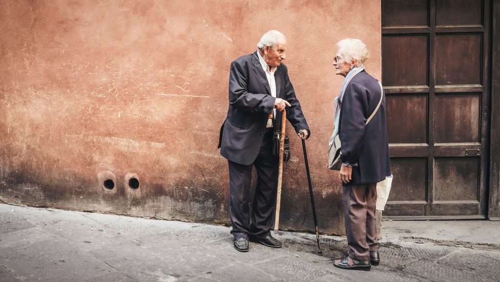Two elderly people having a conversation while standing. Small talk is not common Swedish culture.