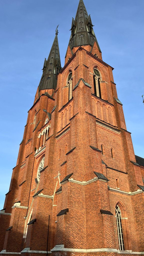 A picture of the exterior of the Uppsala Cathedral, showing its twin spires and Gothic style.