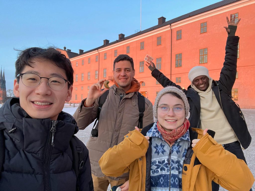 A selfie of me and my three friends smiling outside the Uppsala Castle in our day trip to Uppsala