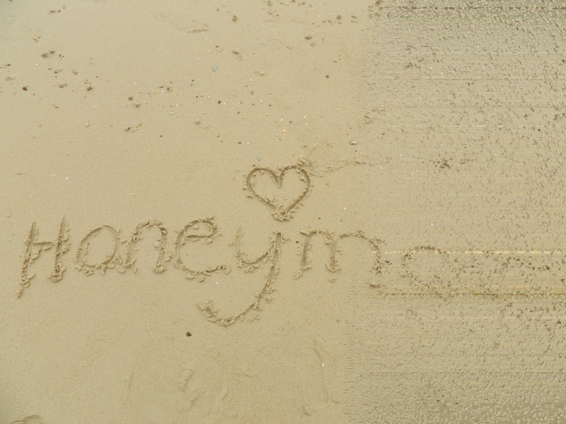 honeymoon letter on beach sand partly washed