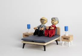 Two lego characters: an elderly man and woman sitting up in bed.