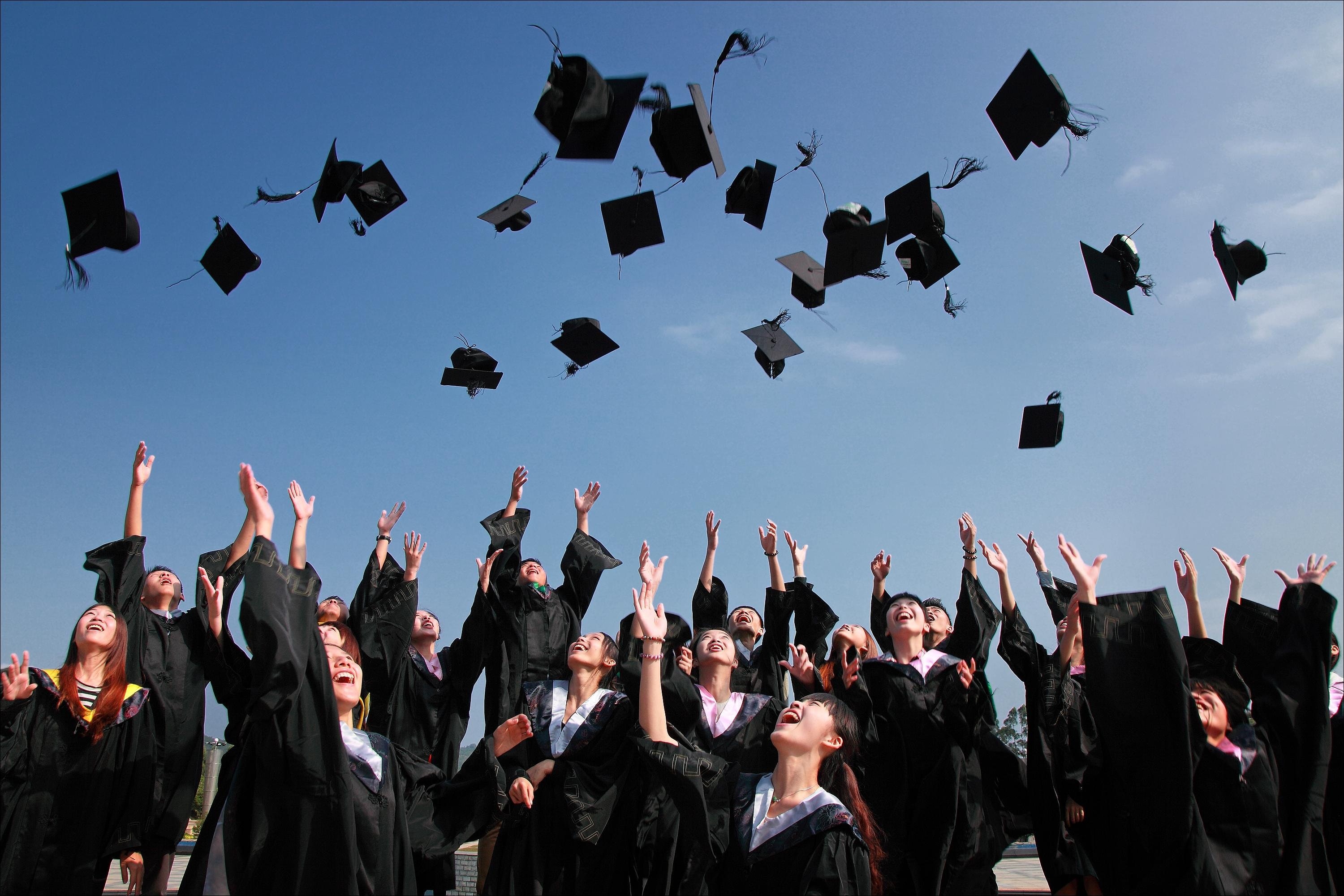 Graduates throwing up their caps in to the air.