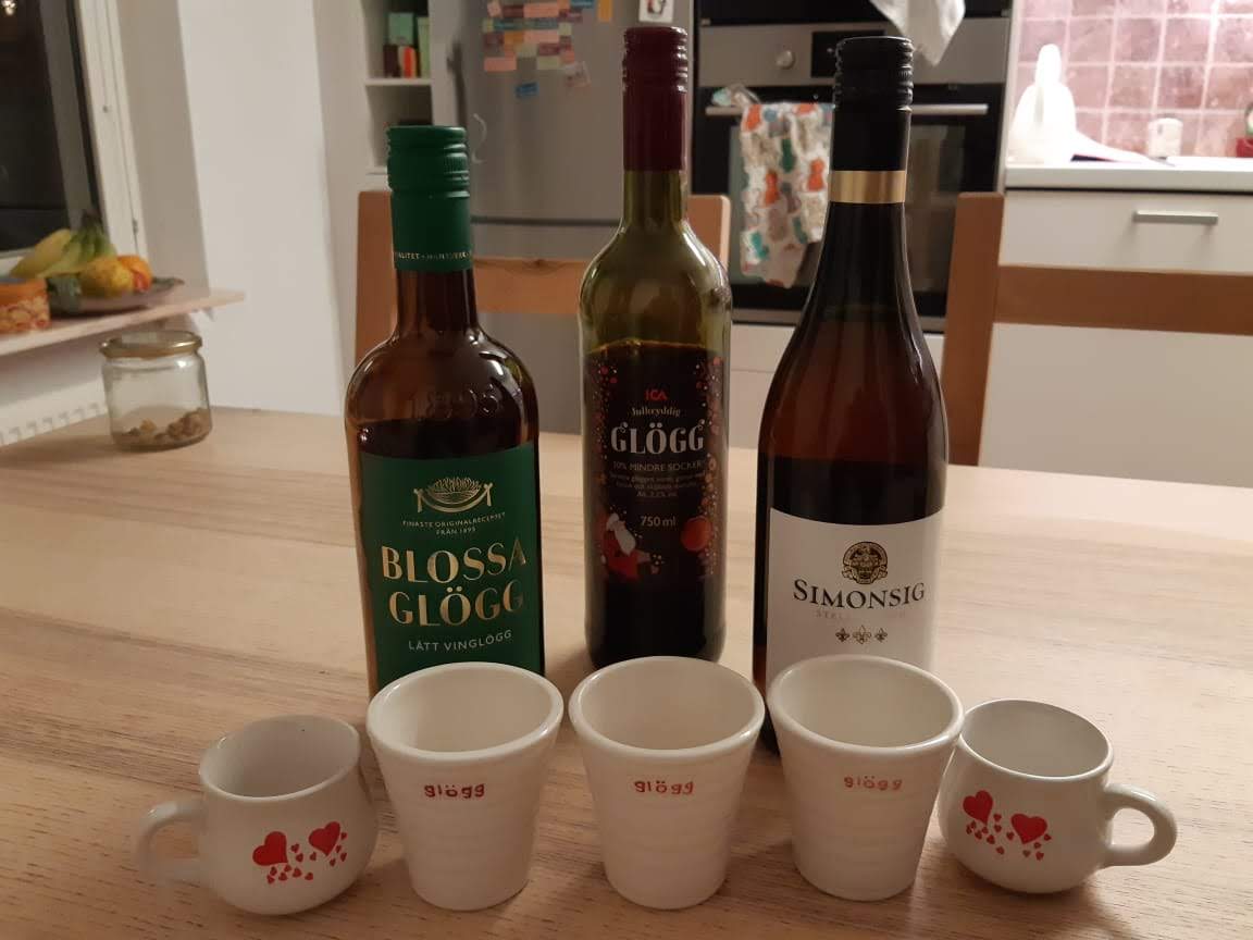 three bottles of glögg with little glögg cups