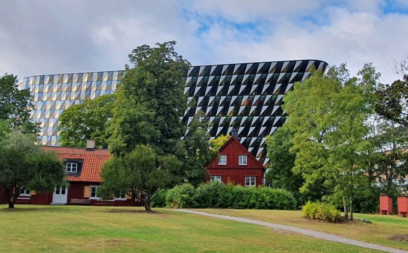 Aula Medica building behing houses and trees