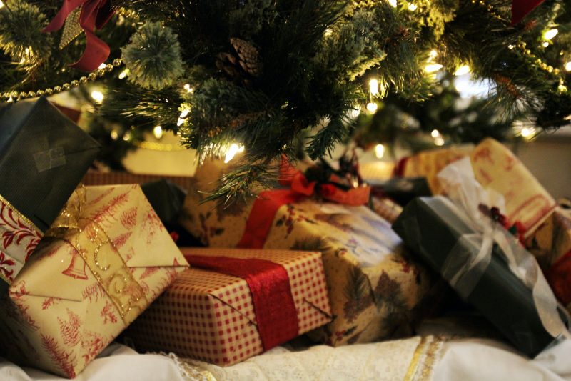 A set of presents under a warmly lit christmas tree