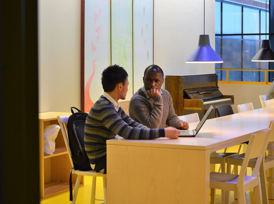 Two students sit facing each other on a table at Widerströmskahuset