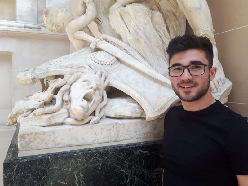 Vlad Popescu next to a medusa statue