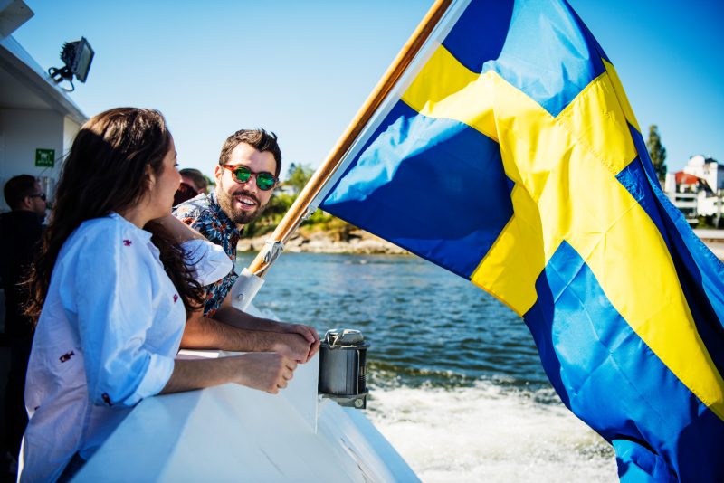 People next to a Swedish flag