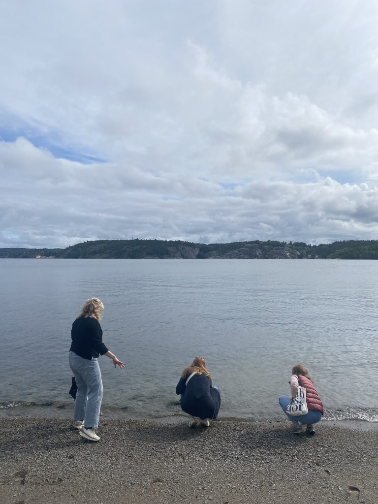 A photo of three girls on a beach in front of the ocean