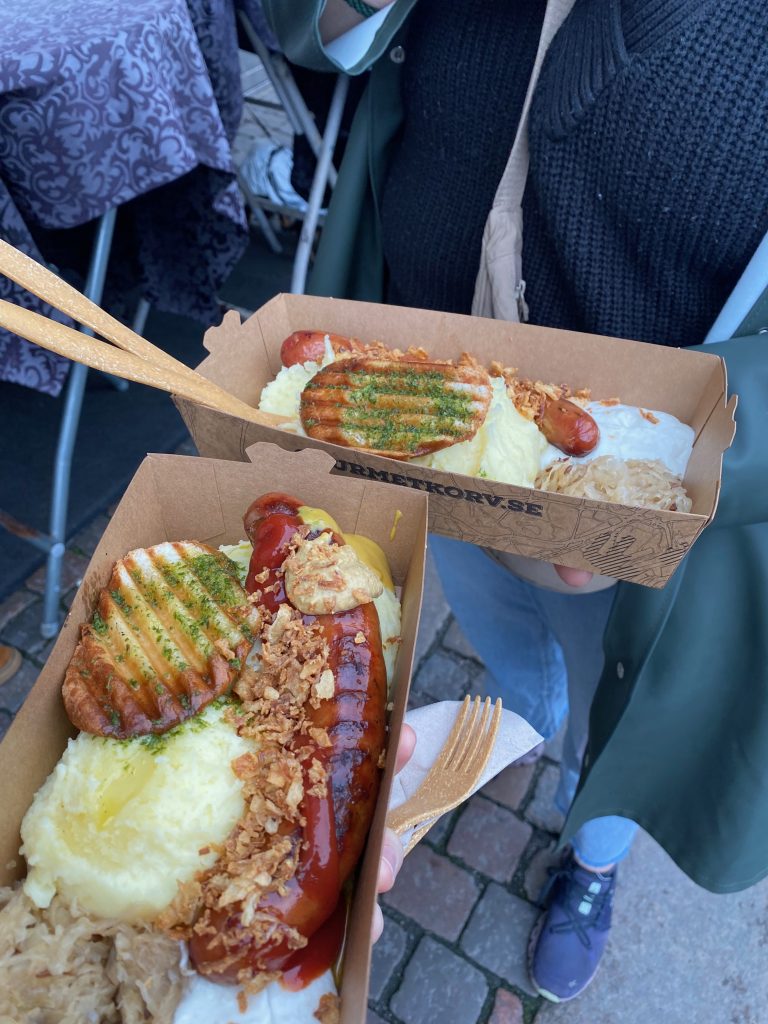 A photo of two hot dogs with sides
