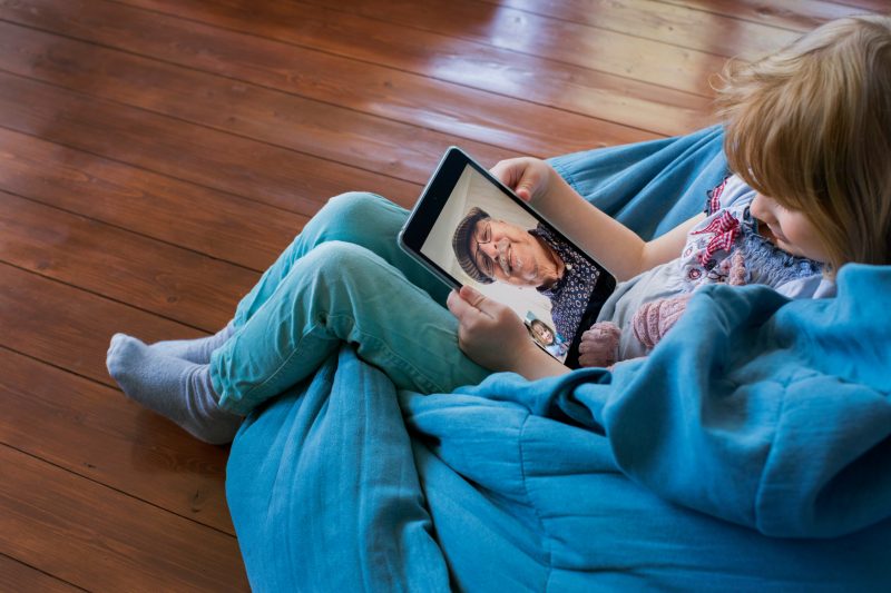 A girl on video chat with an elderly man. Keeping in touch with family is important as a homesickness tip for students.