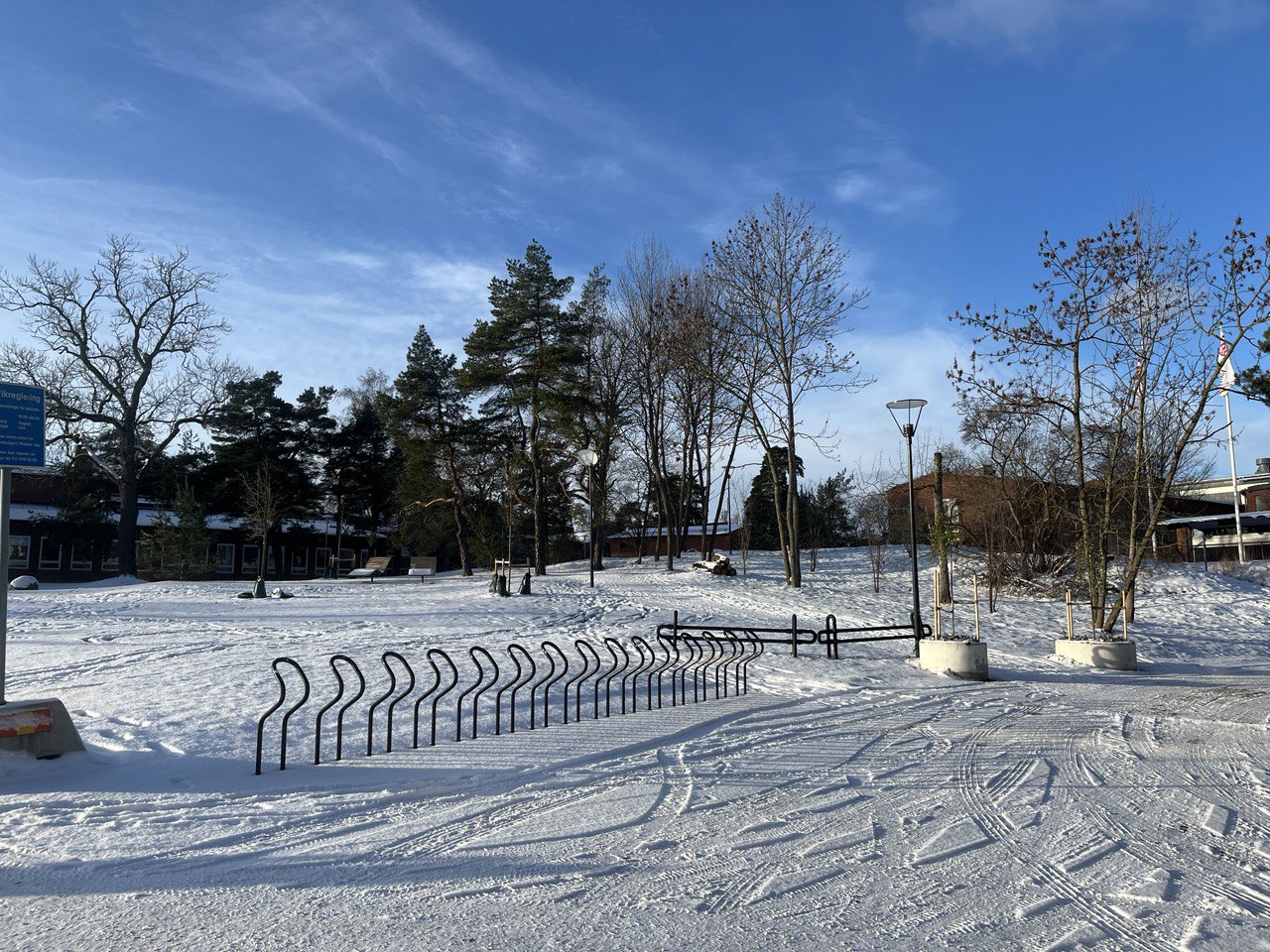 A snowy landscape with building and bicycle racks