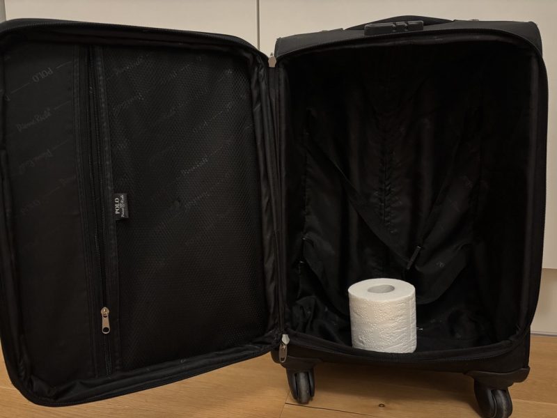 A suitcase containing only a roll of toilet paper