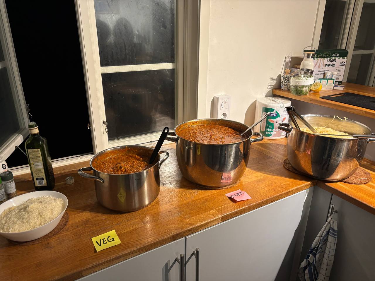 Big pots of bolognese pasta sauce, cooked pasta, cheese all put out to serve the students.