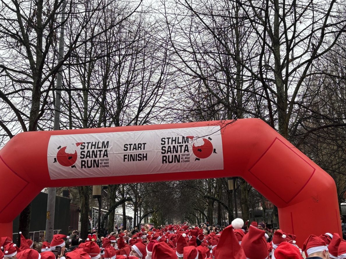 The start banner for the Santa Run with a sea of red Santa hats waiting for the start of the run.
