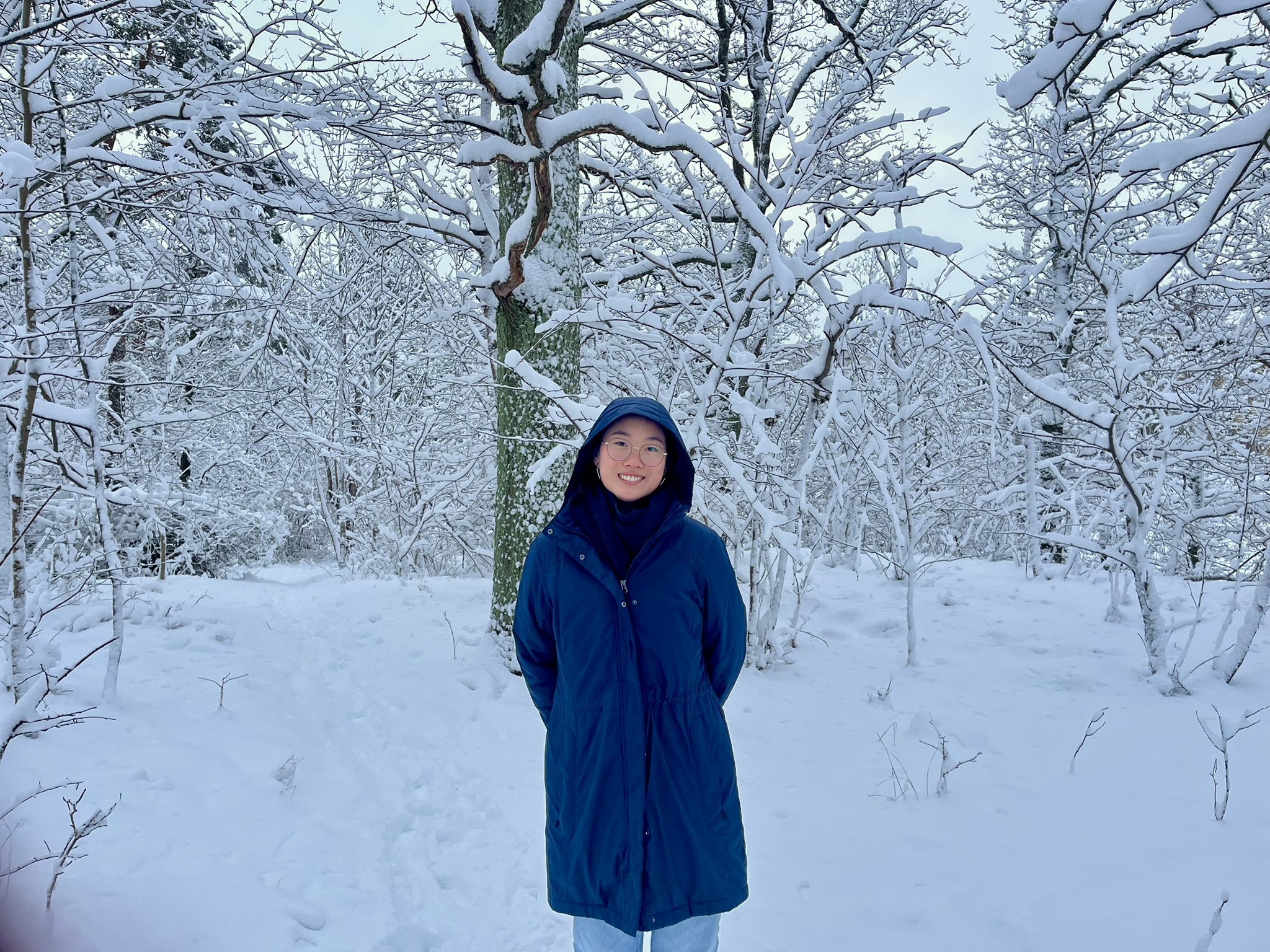 A girl in a blue jacket amidst the snowy landscape