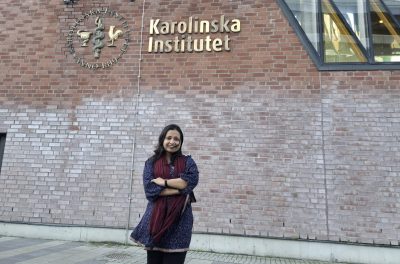 Student in front of Karolinska Institutet sign