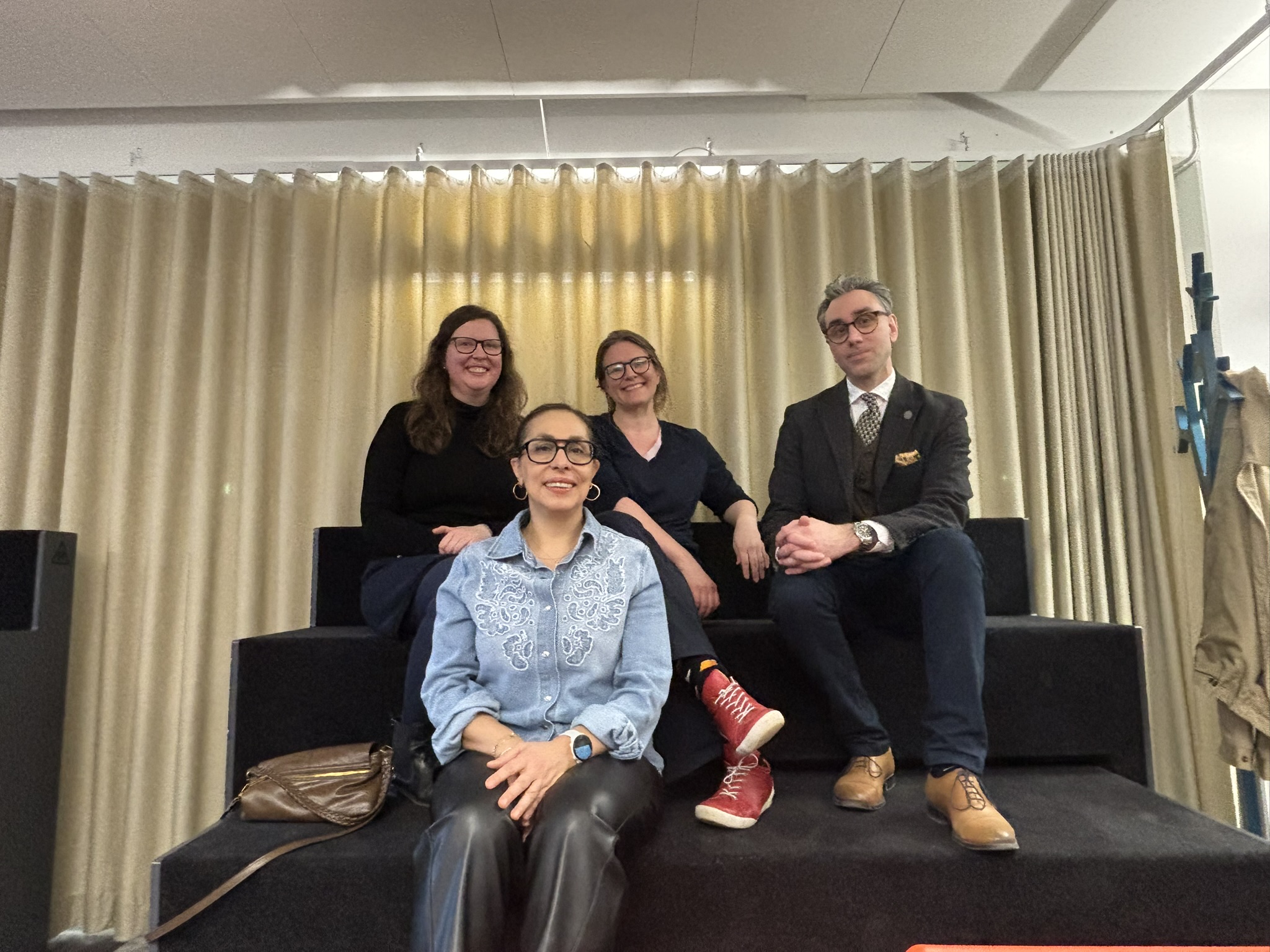 A team sitting on a two tiered (staircase like) seating.