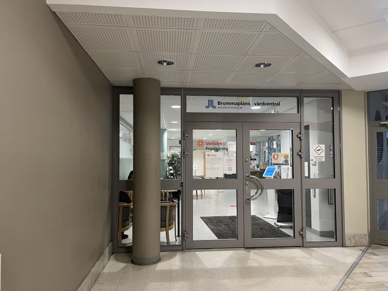 A photo of the entrance of a vårdcentral, showing the glass door.