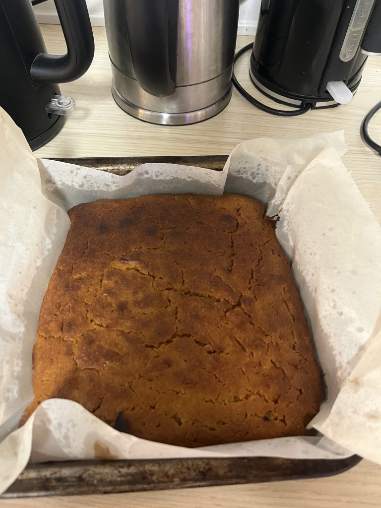 A cake-pan with fresh-baked pumpkin bread on a kitchen table.