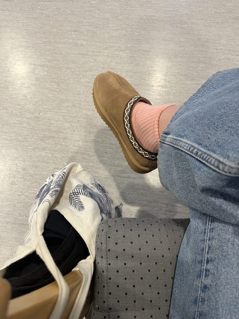 A snapshot of my leg, showing my foot, wearing winter slippers.