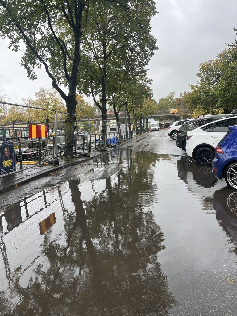 A huge deep puddle on a parking area.